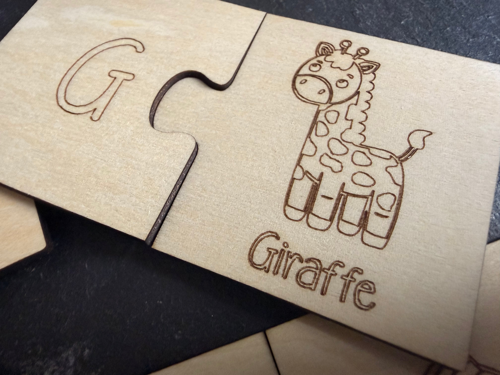 Light-colored wooden puzzle by flyliving, with interlocking pieces showing an engraved 'G' and a giraffe illustration with 'Giraffe' text.