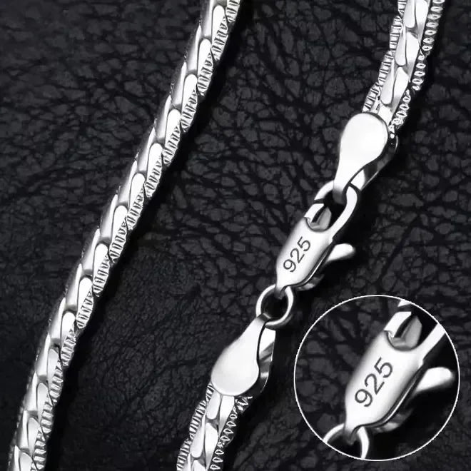 Eine Nahaufnahme der flyliving Halskette „Horst-Peter“, einer silbernen Gliederkette mit einem 925er Sterlingsilber-Karabinerverschluss, dargestellt auf strukturiertem Schwarz. Ein Einschub hebt die 925er-Markierung auf dem Verschluss hervor.