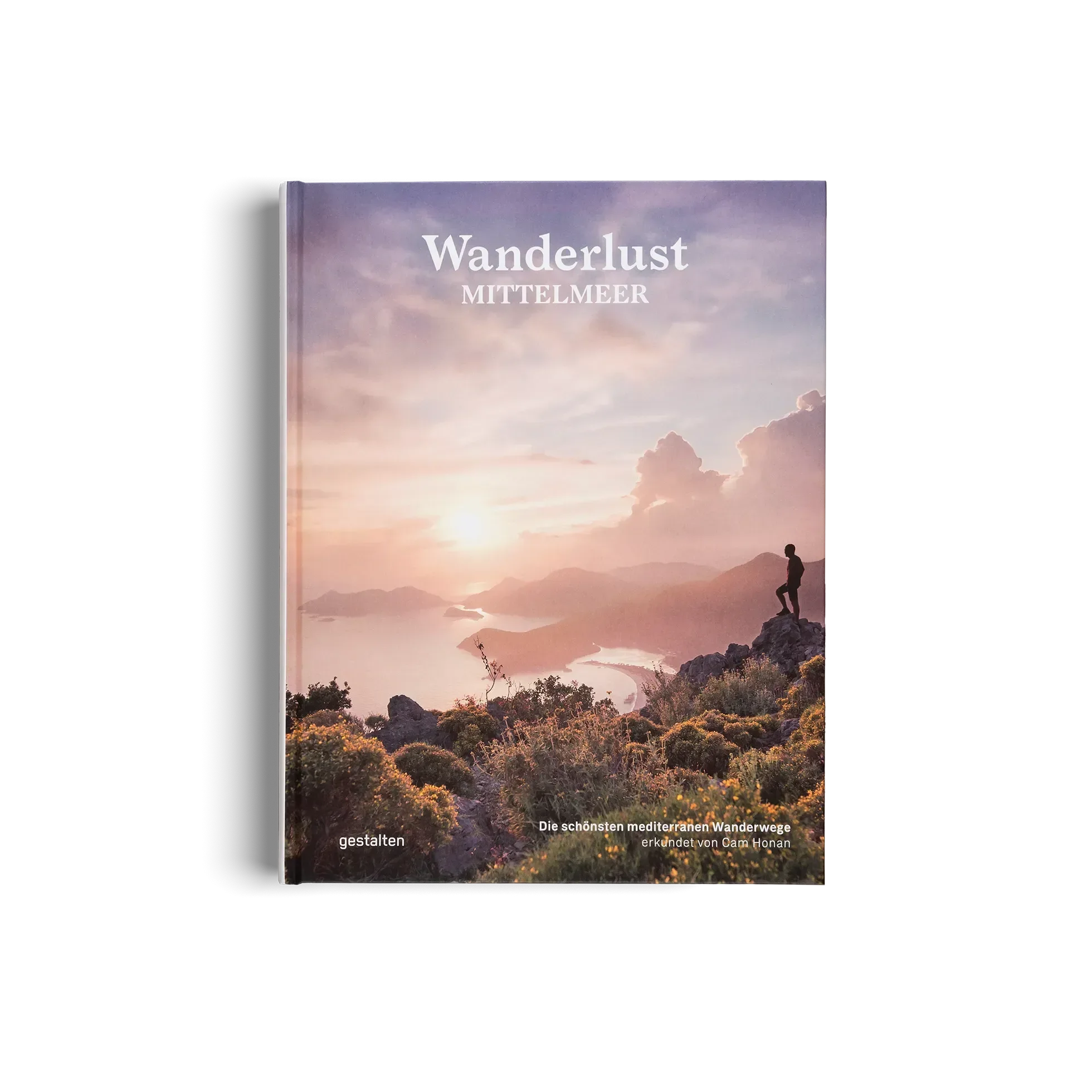 Das Cover von Wanderlust Mittelmeer von gestalten EU Shop zeigt einen Wanderer, der auf eine sonnenbeschienene Küste blickt und macht Lust auf mediterrane Wanderwege und inspirierende Wandertipps für die Region.