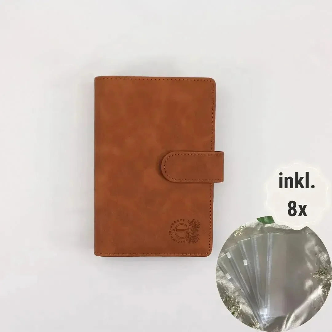 A BeginnerBudget Budget Binder (veganes Wildleder, A6, Braun) liegt mittig auf weißem Hintergrund. Ein Inset zeigt 8 transparente Hüllen für bessere Finanzübersicht mit dem Text "inkl." daneben. 8x" daneben.
