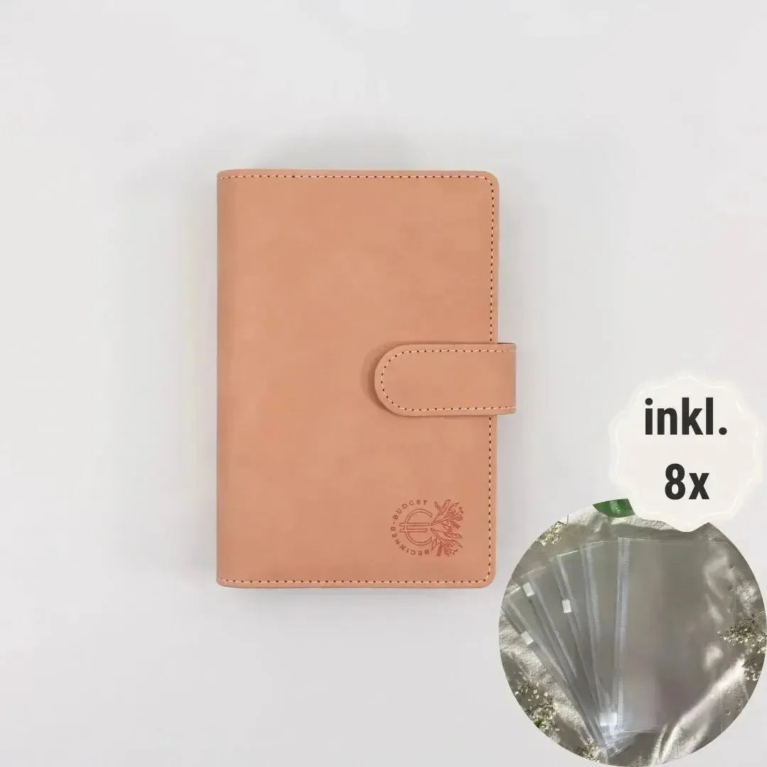 Ein rosa, veganes Wildleder-Budget Binder (A6) von BeginnerBudget mit Druckknopf liegt zentriert auf weißem Hintergrund. Ein Inset zeigt 8 transparente Hüllen für optimale Finanzübersicht, daneben steht inkl. 8x.
