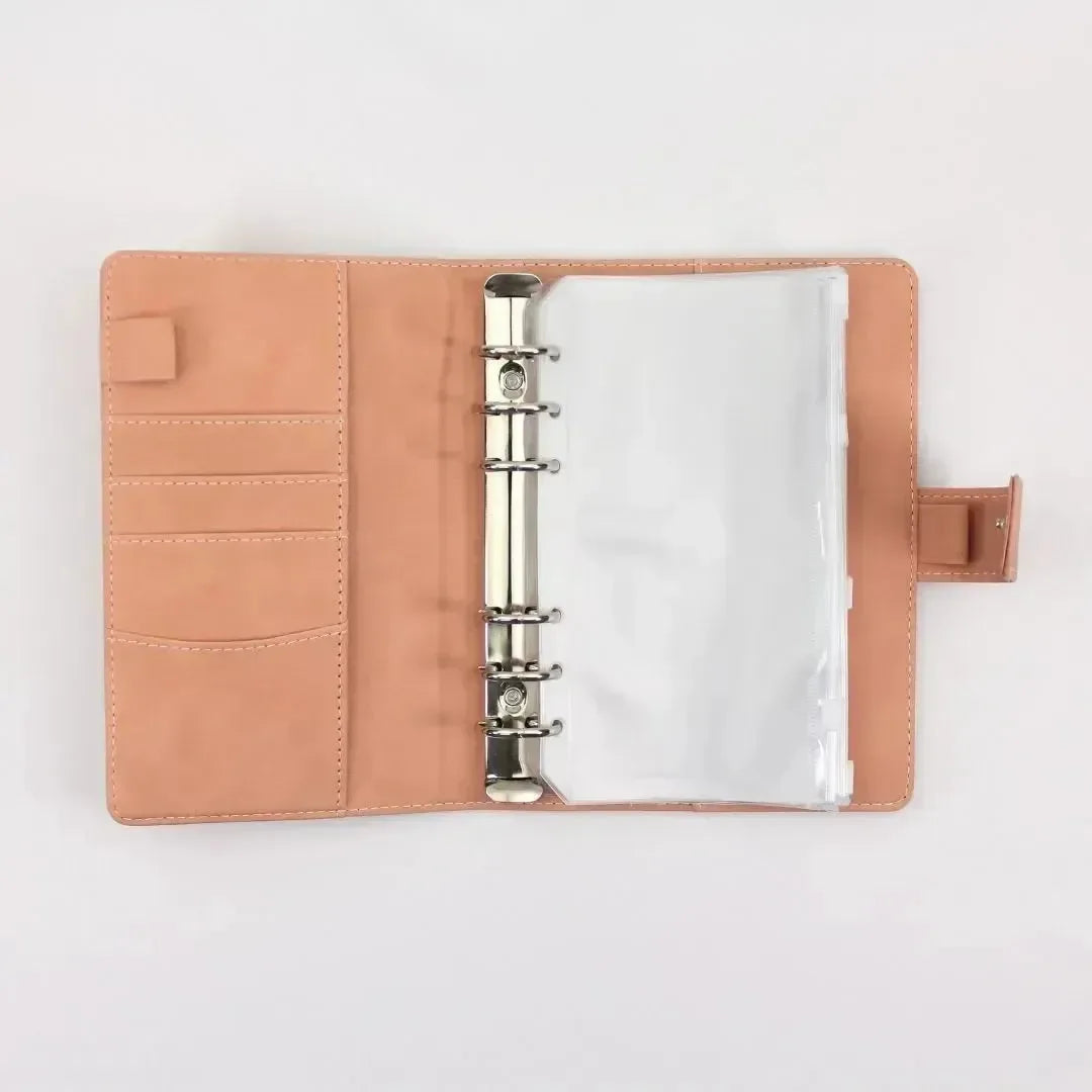 Der BeginnerBudget Budget Binder (veganes) Wildleder - Personal (A6) verfügt über hellbraunes veganes Wildleder, eine Ringmechanik, Kartenfächer links und Klarsichthüllen rechts - ideal für Ihre Finanzübersicht und Sparen - auf einem schlichten weißen Hintergrund.