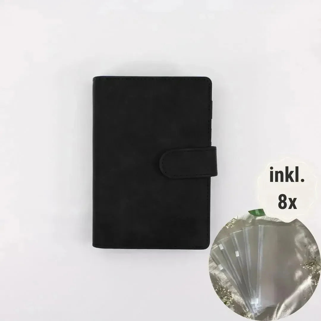 A BeginnerBudget Budget Binder (veganes Wildleder, A6, schwarz) mit Druckknopf liegt mittig auf weißem Hintergrund. Ein Inset zeigt 8 transparente Hüllen ("inkl. 8x"). Perfekt für Finanzübersicht und Sparen.