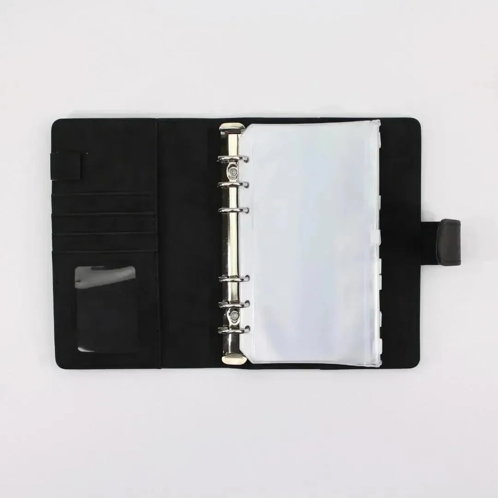 Der BeginnerBudget Budget Binder (veganes) Wildleder - Personal (A6) in schwarz ist offen auf einer weißen Oberfläche, mit Kartenfächern, einer Klarsichttasche für den Personalausweis und mehreren transparenten Schutzblättern - perfekt zum Organisieren von Sparen oder Ihrer Finanzübersicht.