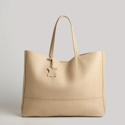 Die Umhängetasche "Susi" von flyliving aus dunkelgrauem Leder überzeugt mit zwei Henkeln und sternförmigem Anhänger - stilvoll präsentiert vor hellgrauem Hintergrund, die ideale Damenhandtasche für jeden Anlass.