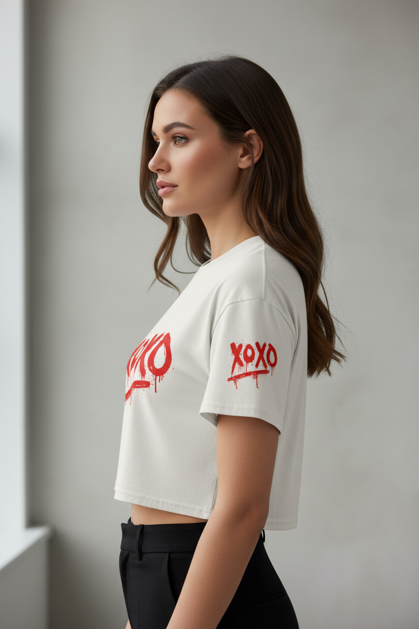 White combed cotton relaxed fit crop top by flyliving, with a red 'xoxo' graffiti graphic, side view.