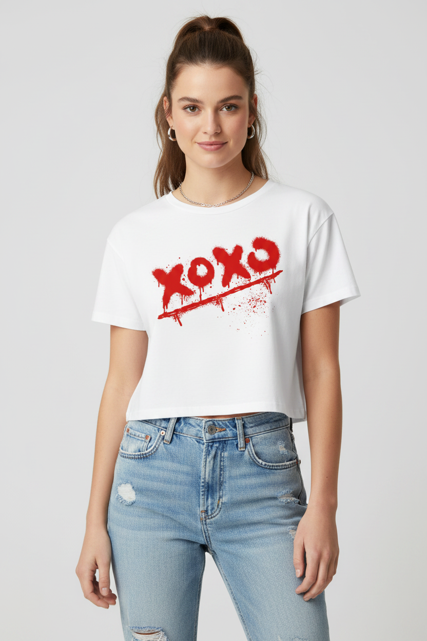 White combed cotton relaxed fit crop top by flyliving featuring a red "xoxo" spray-paint graphic, worn with distressed jeans.