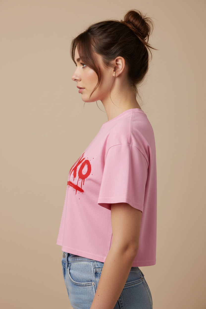 Pink 100% combed cotton relaxed fit women's crop top by flyliving with a red 'xoxo' spray paint graphic, side view.