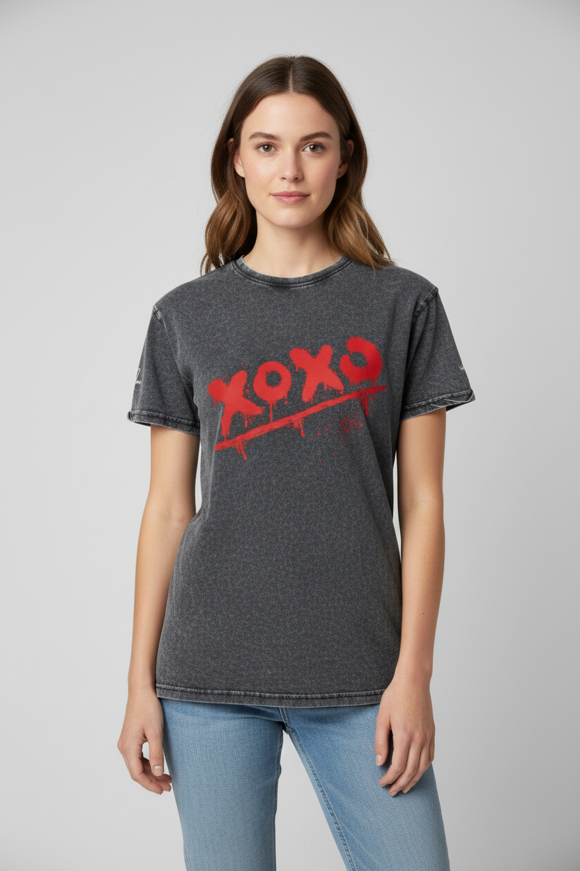 Washed charcoal cotton t-shirt by flyliving with a distressed red 'XOXO' graphic and paint drips, worn by a woman.