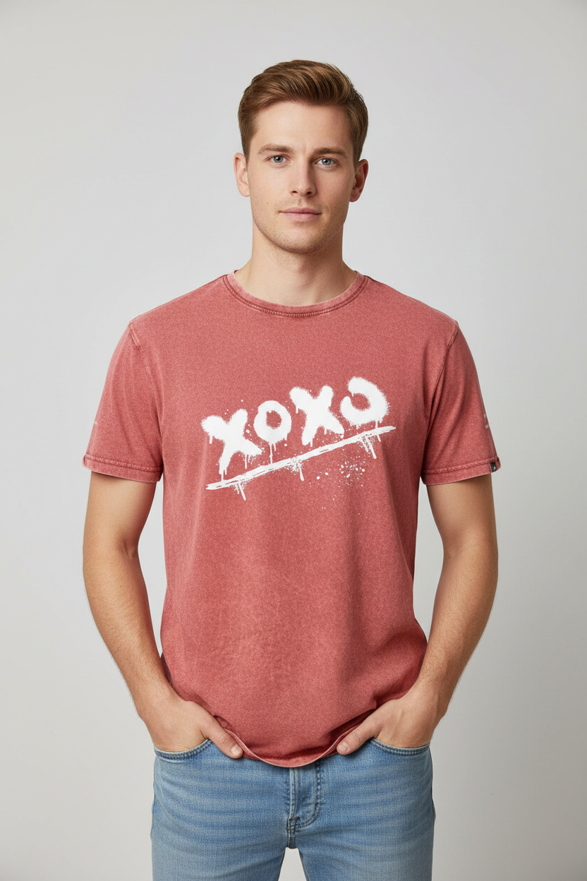 Faded rust red cotton T-shirt by flyliving with white "xoxo" spray-paint graphic, worn by a man in blue jeans.