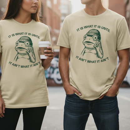 Beiges kurzarmshirt mit bedrucktem grünen frosch und spruch it is what it is until it ain’t what it ain’t