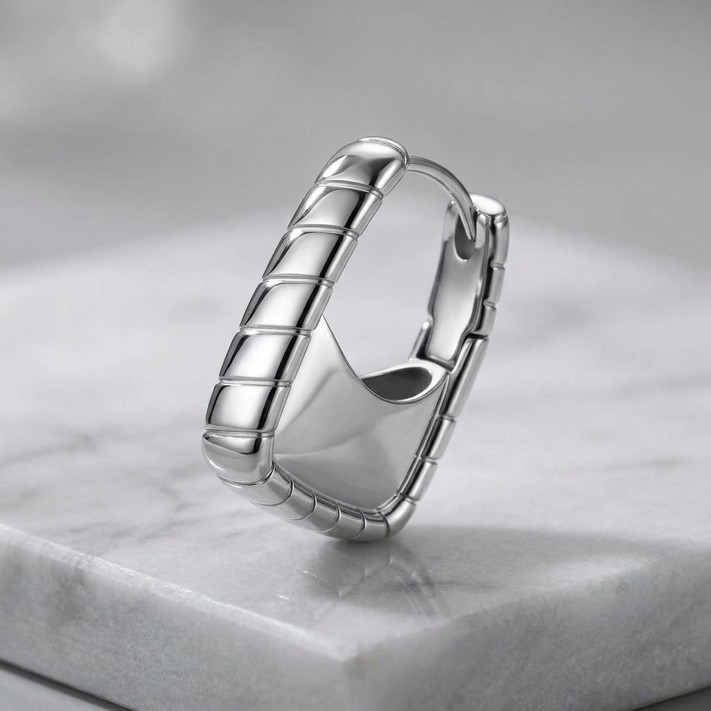 Platinum-plated 925 sterling silver textured hoop earring by flyliving, featuring a ribbed design and smooth inner surface on marble.
