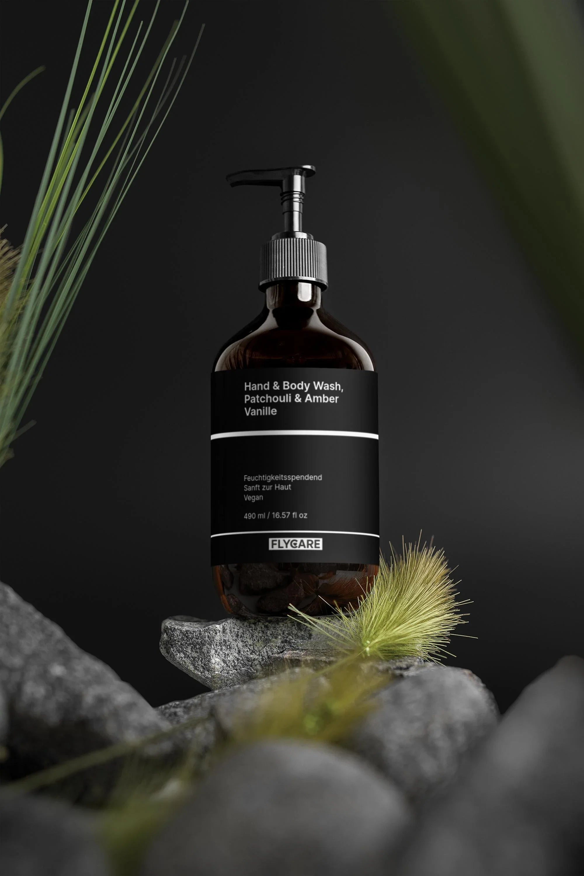 Bernsteinfarbene Hand- und Körperwaschlotion Patchouli & Amber Vanille von Flycare, auf einem grauen Felsen mit Gras im Vordergrund.
