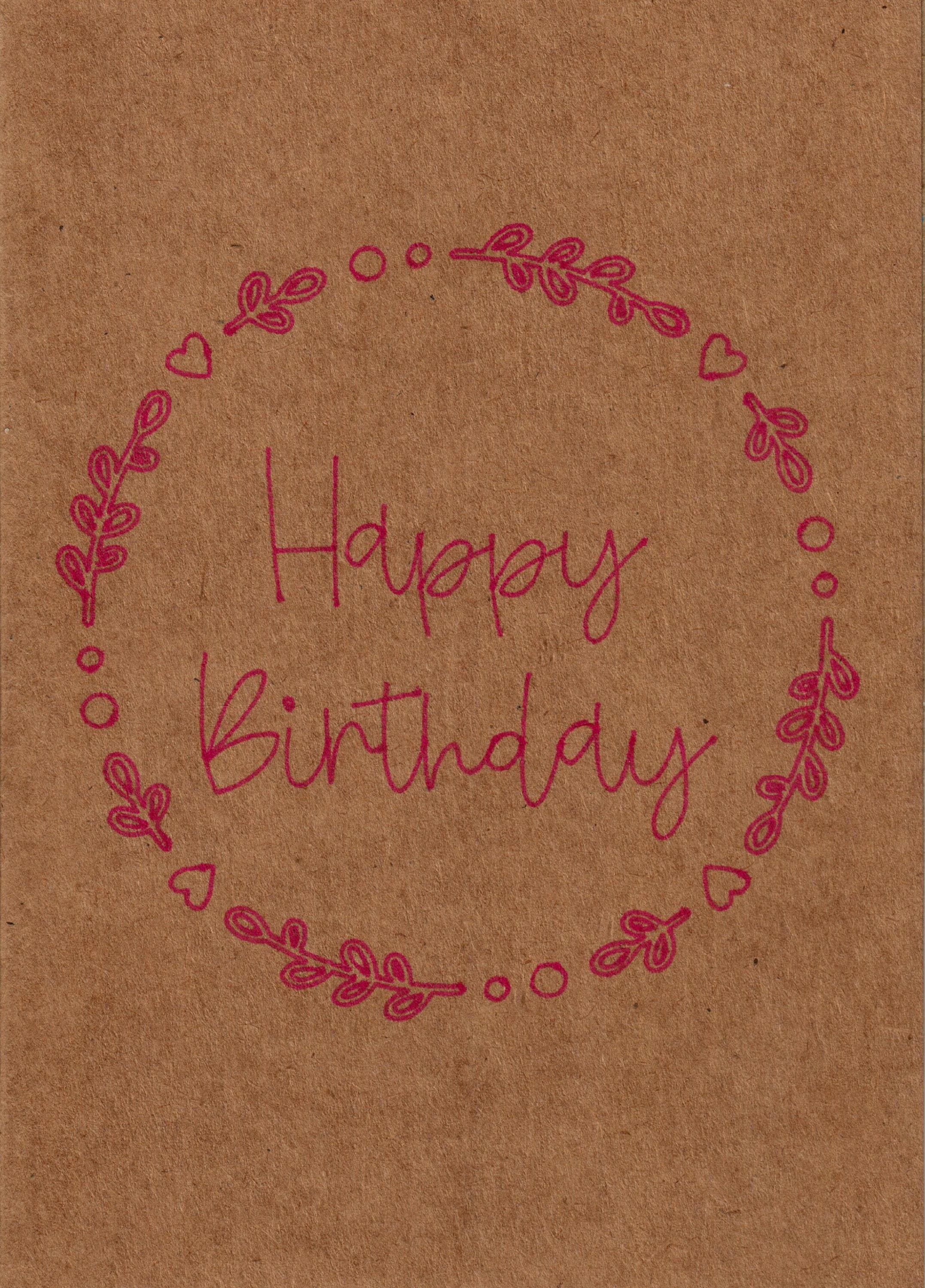 Geburtstagskarte aus braunem Kraftpapier mit pinkem Schriftzug „Happy Birthday“ und floraler Verzierung aus Blättern und Herzen. Nachhaltiges Design, ideal für umweltbewusste Glückwünsche. Perfekt für persönliche und stilvolle Geburtstagsgrüße.