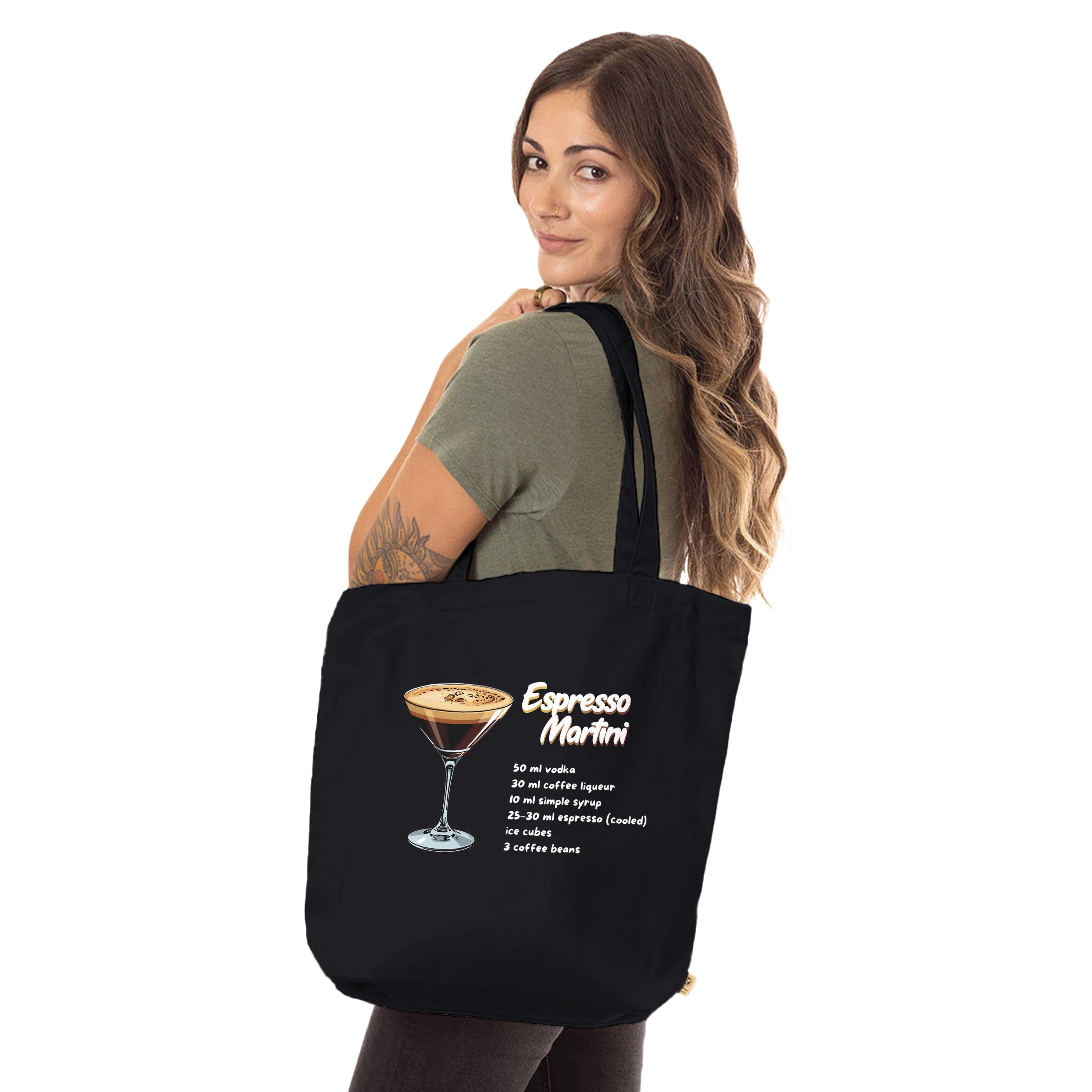 Schwarze Jutetasche mit Espresso Martini-Rezept von flyliving, getragen von einer Frau mit olivgrünem Shirt.