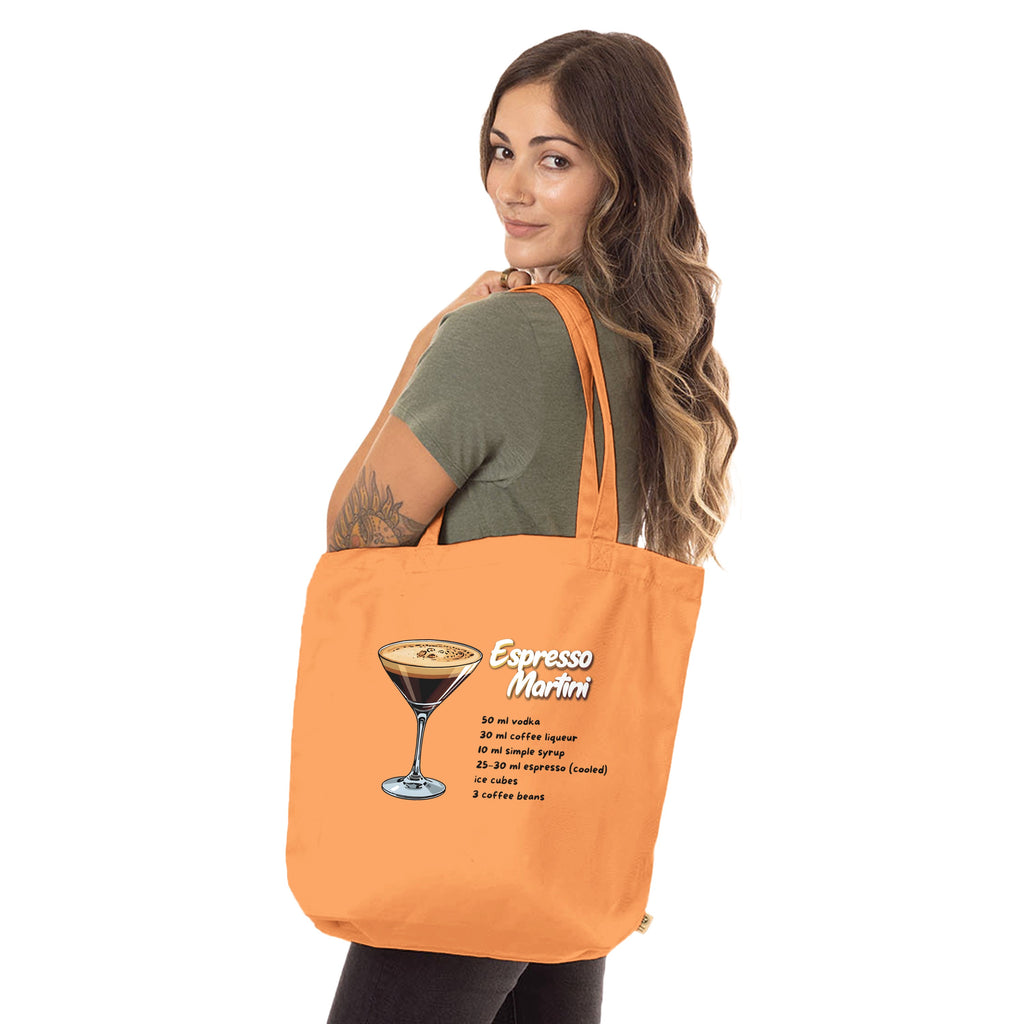 Oranger Jutebeutel Espresso Martini mit Rezept von flyliving, getragen von einer Frau mit olivgrünem T-Shirt.