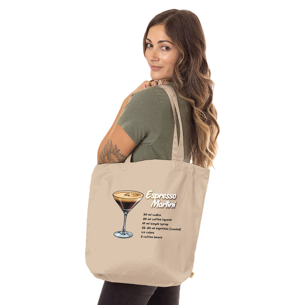 Beiger Jutebeutel mit Espresso Martini Rezept von flyliving, mit Cocktail-Illustration und Text, getragen von einer Frau mit olivgrünem T-Shirt.
