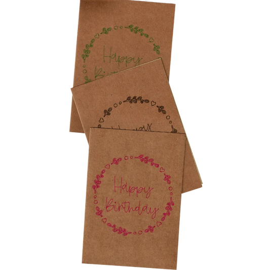 Geburtstagskarten aus braunem Kraftpapier mit verschiedenfarbigen Schriftzug „Happy Birthday“ und floraler Verzierung aus Blättern und Herzen. Nachhaltiges Design, ideal für umweltbewusste Glückwünsche. Perfekt für persönliche und stilvolle Geburtstagsgrüße.