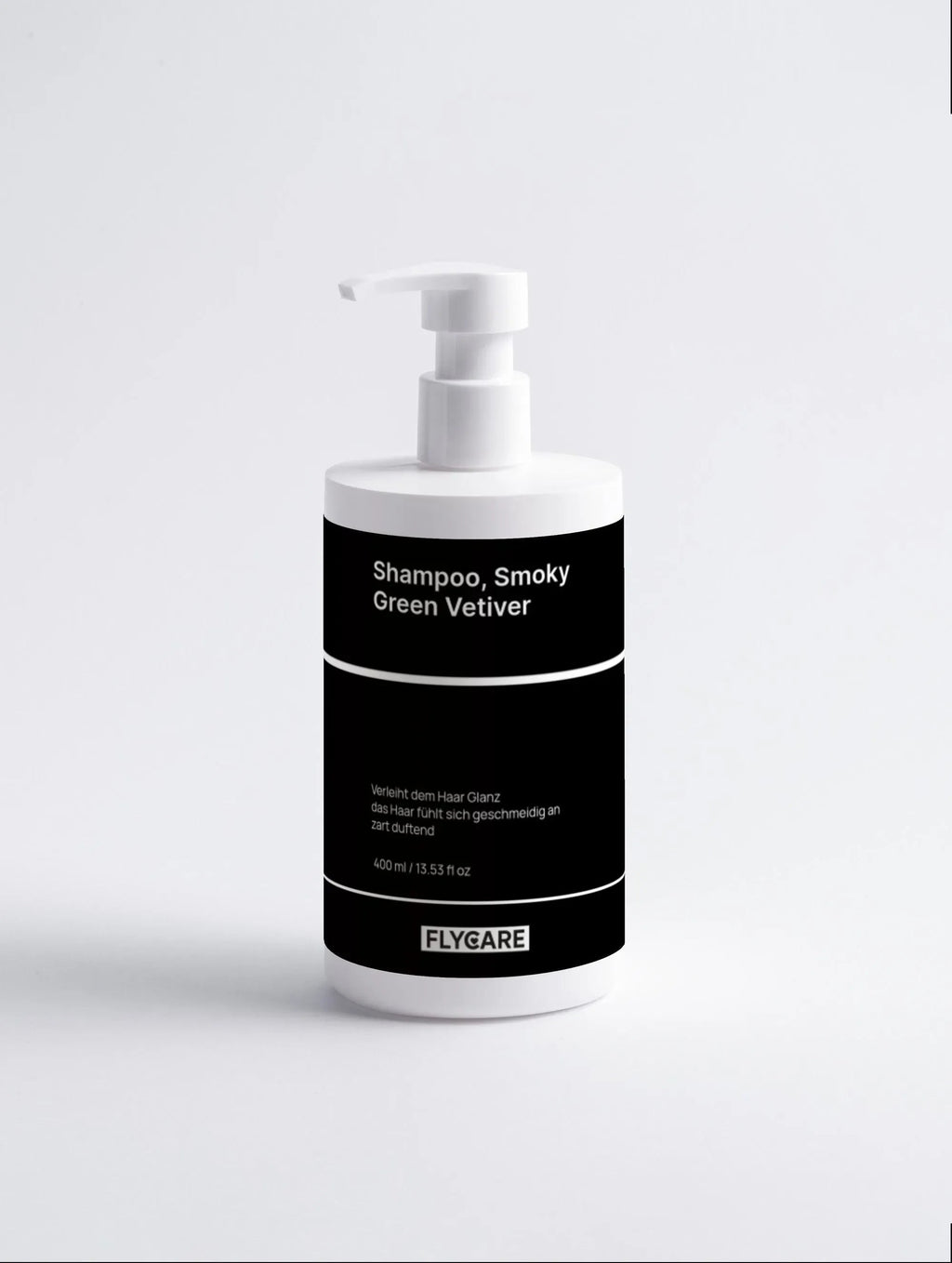 Shampoo Smoky Green Vetiver von Flycare in weißer Spenderflasche mit schwarzem Etikett vor hellem Hintergrund.
