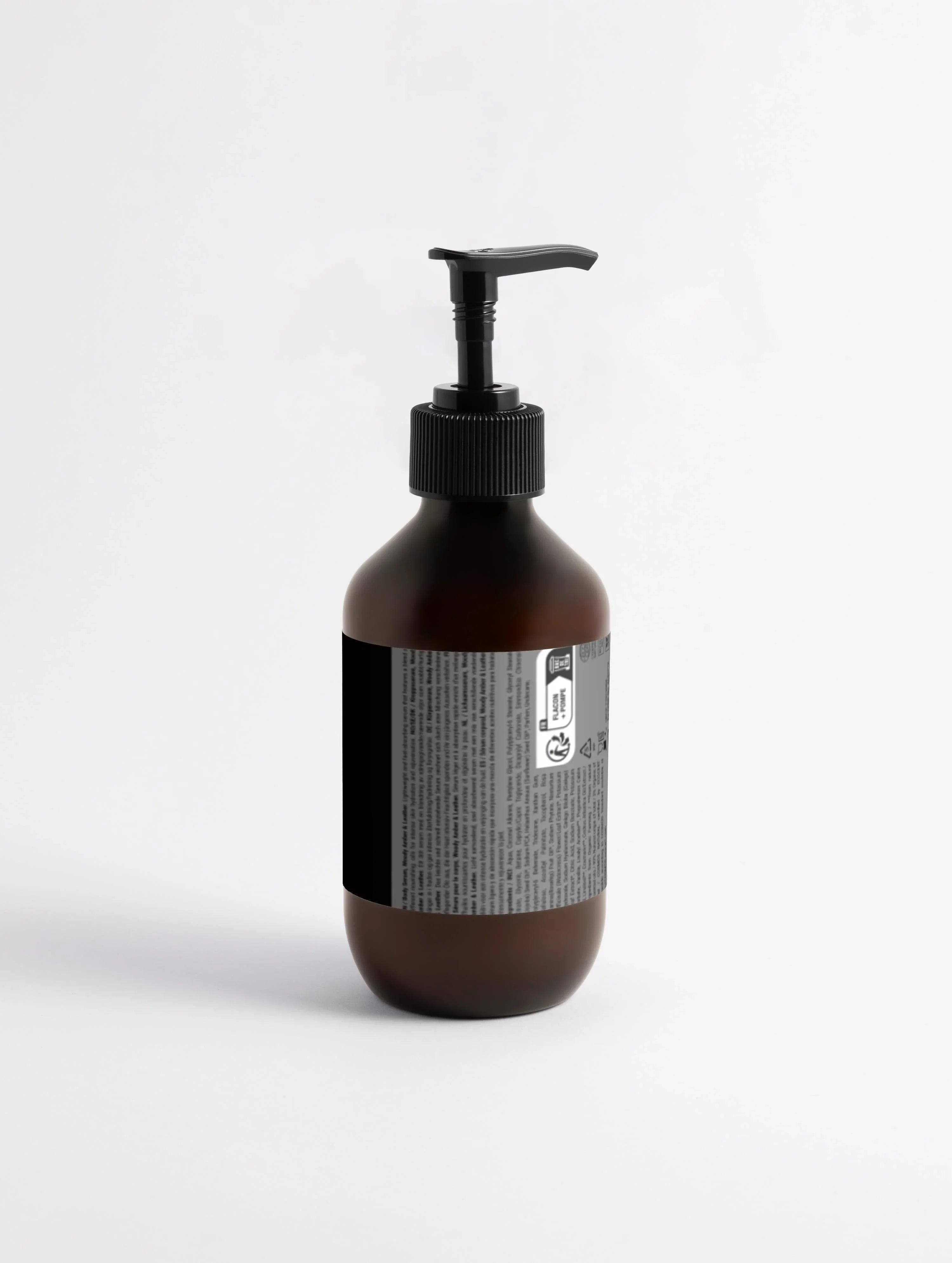 Hautserum mit holzigem Amber- und Lederduft von flyliving, braune Flasche mit schwarzem Spender vor einem weißen Hintergrund.
