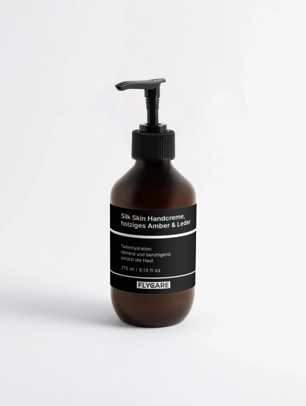 Braune Handcreme mit Amber- und Lederduft von Flycare, in einer bernsteinfarbenen Glasflasche mit schwarzem Pumpspender.