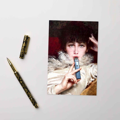 Vintage-Postkarte mit rauchender Dame und E-Zigarette auf weißem Untergrund neben einem goldenen Füllfederhalter