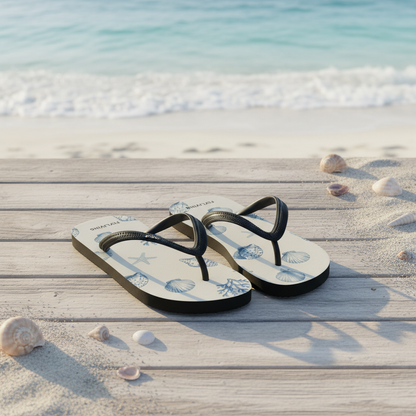 Leichte weiße flip-flops mit schwarzen riemen und blauem muschelprint auf holzsteg am strand
