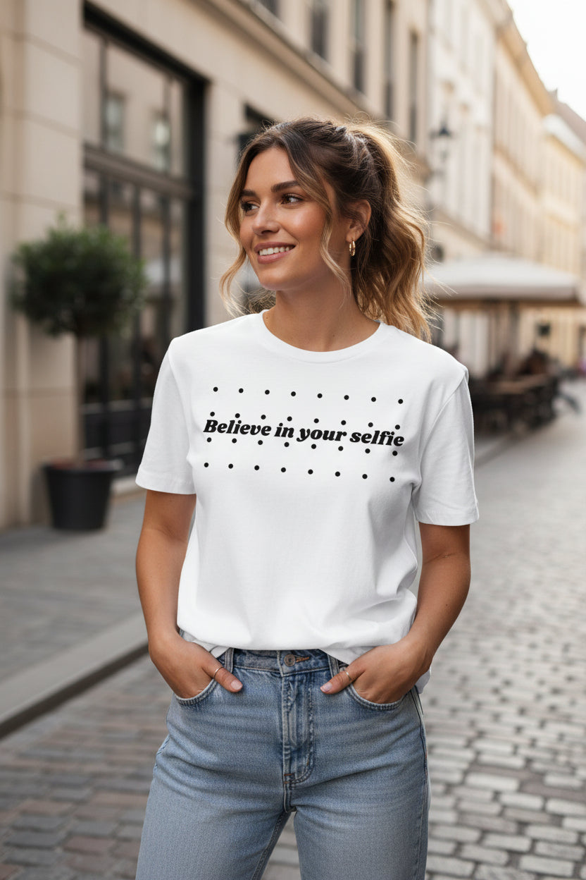 White cotton T-Shirt by flyliving featuring "Believe in your selfie" text and black polka dots, worn with light wash jeans.