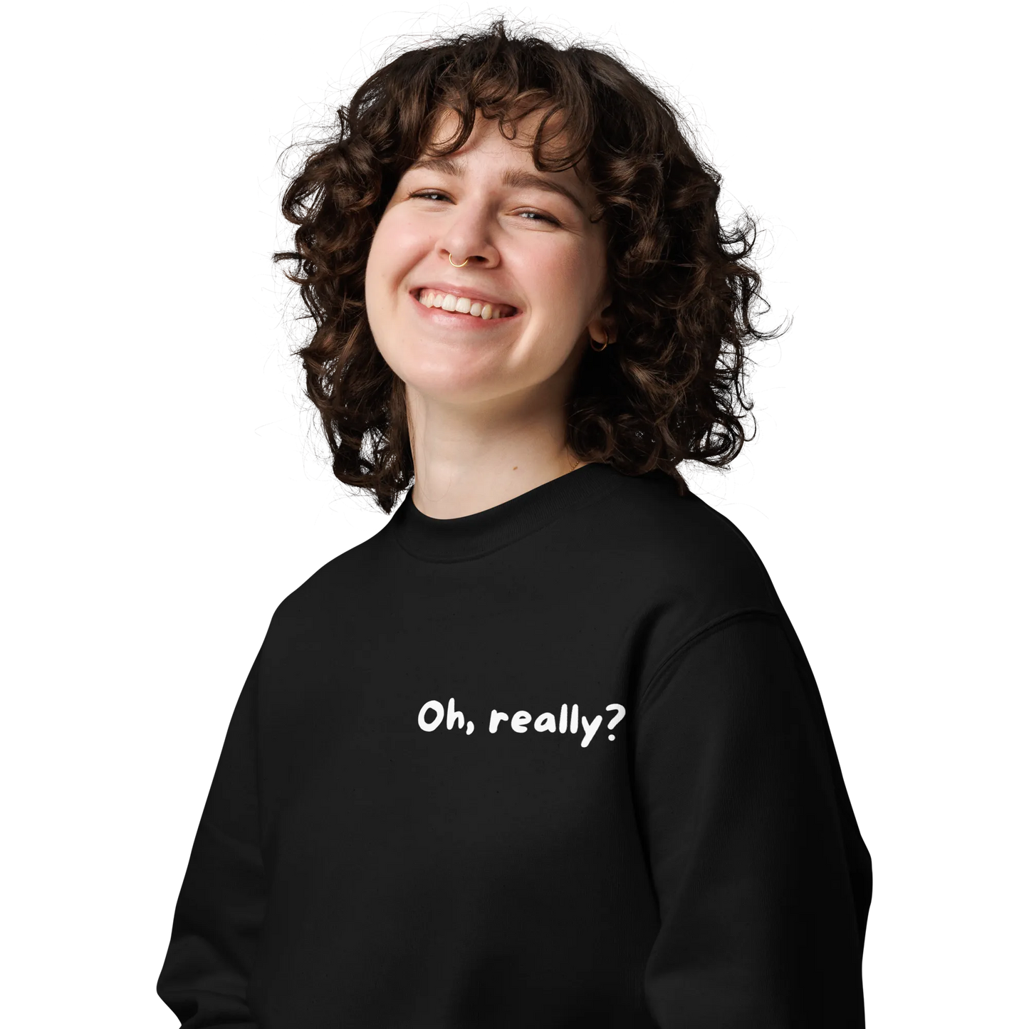 Eine Person mit lockigem Haar lächelt breit und trägt den flyliving Pullover "Oh, really?" mit weißem Text auf der Vorderseite. Der Hintergrund ist einfarbig und dunkel.